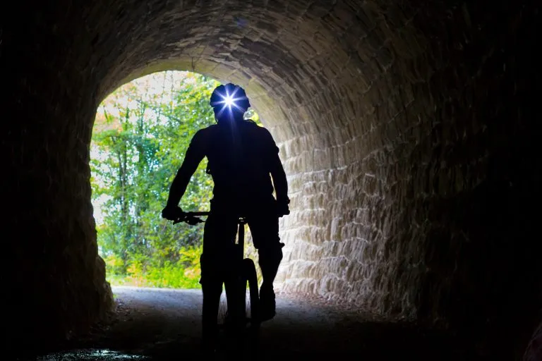Croatien, Istria, Parenzana Biketrail, Maastopyöräilijä otsalamppu päässä tunnelissa
